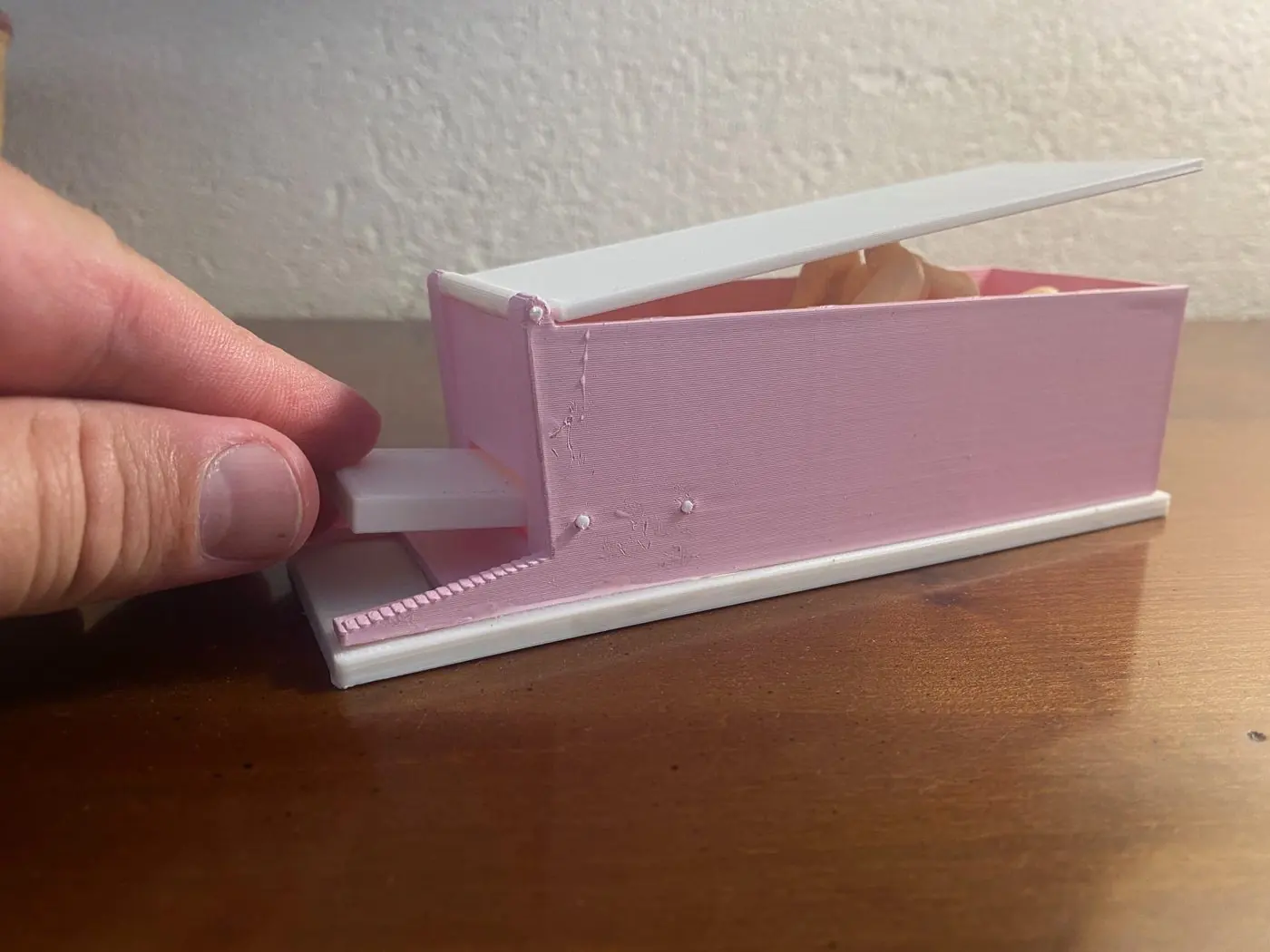 Boîte imprimée rose et blanche, couvercle relevé et tiroir à crémaillère sorti