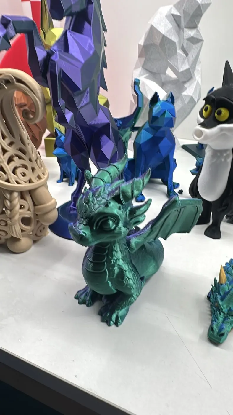 Étagère d'atelier garnie de figurines imprimées : dragons, renard low-poly, sphère ajourée, chat bicolore