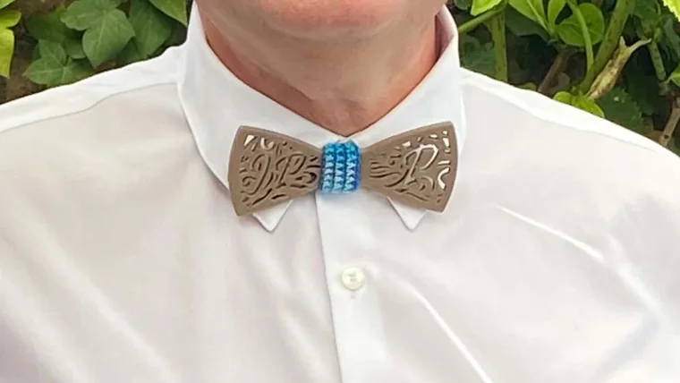 Le même nœud papillon porté sur une chemise blanche, col ouvert