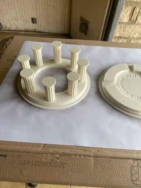 Base circulaire à huit colonnes cannelées imprimée en blanc, avec le plateau gravé posé à côté