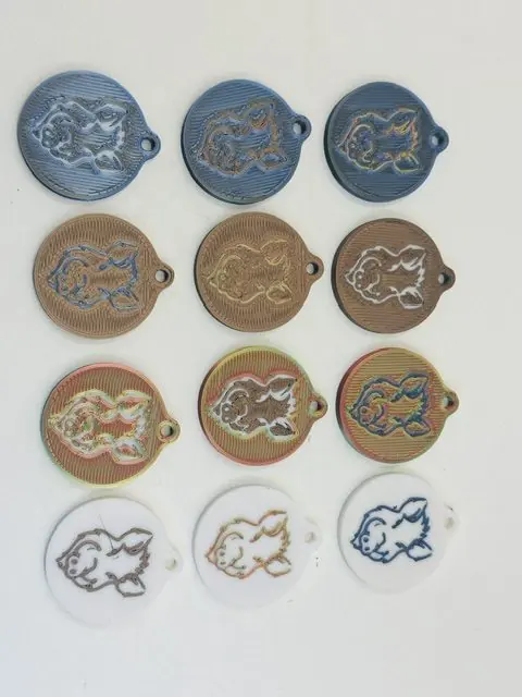 Douze porte-clés identiques rangés en grille, déclinés en quatre matières et trois couleurs de marquage